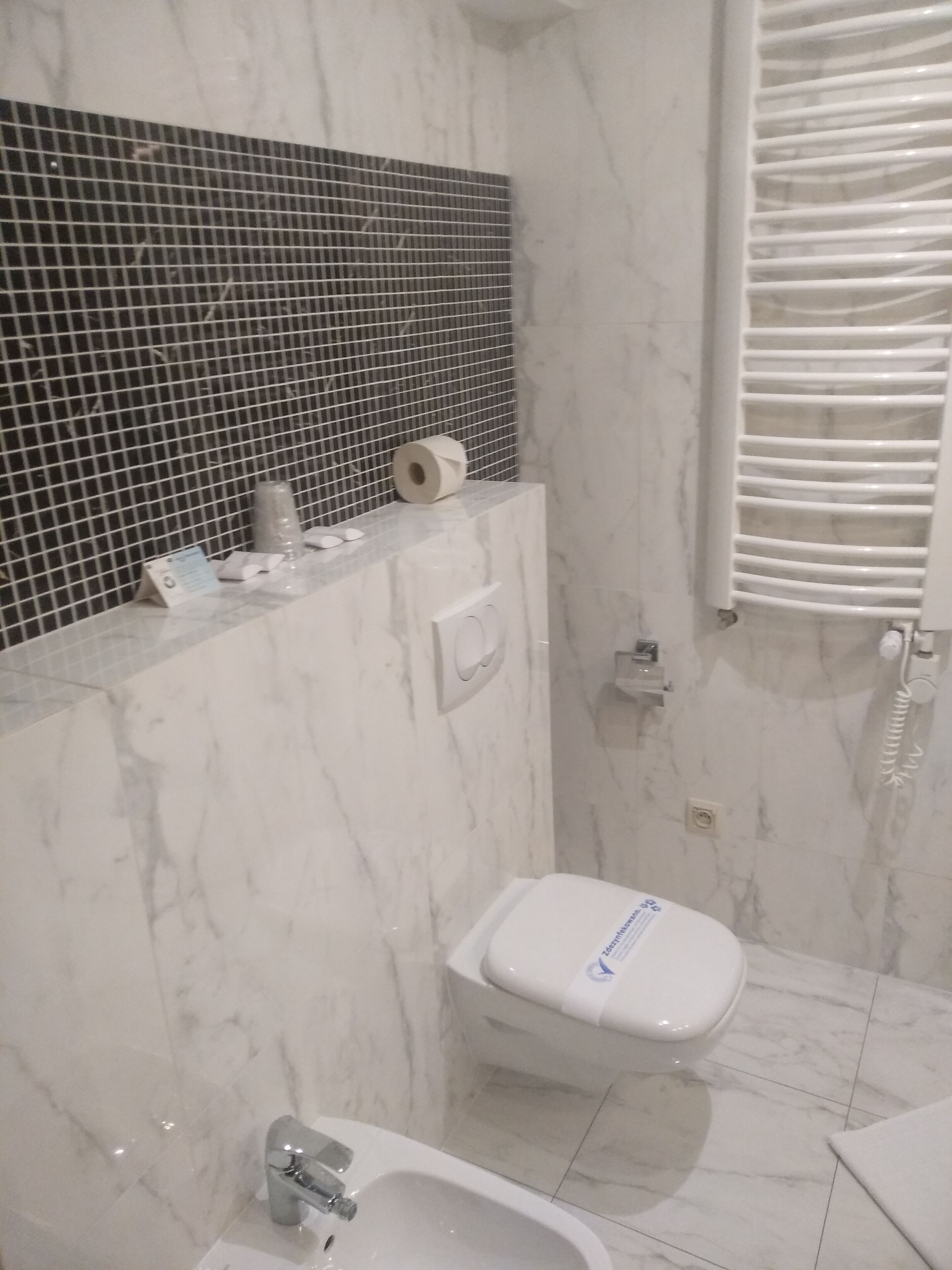 A bathroom with a toilet, bidet, and a sink.