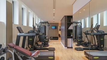 A gym with treadmills, elliptical machines, and weight machines.