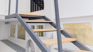 Un appartement moderne doté d’un escalier, d’un balcon et d’une fenêtre.