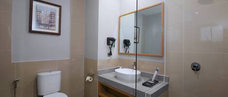 A modern bathroom with a toilet, sink, and shower.