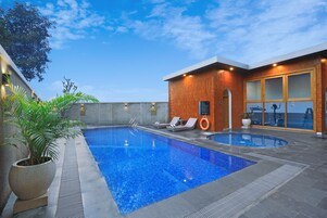 Una piscina interior con sillas de descanso y una planta en maceta.