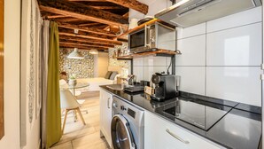 A modern kitchen with a washing machine, a microwave, and a coffee maker. - Beautiful Renovated Loft in the center 010  (Madrid)