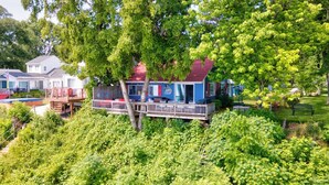 A house with a porch, surrounded by lush greenery and a small garden.
