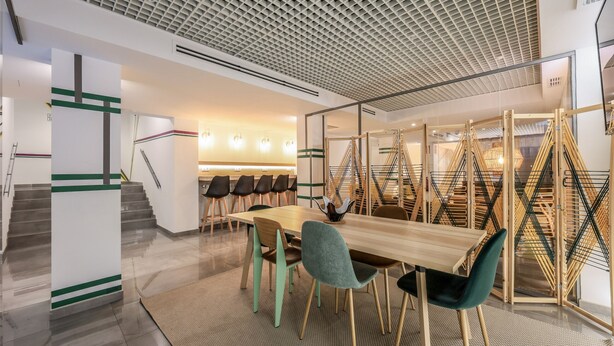 A modern conference room with a wooden table, teal and brown chairs, and a unique ceiling design. - Blasco de Garay, double room with gym 106 (Madrid)