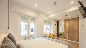 Una camera da letto moderna con un letto grande, una scrivania e uno specchio.
