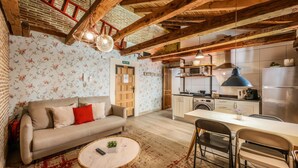 A cozy living room with a sofa, a round coffee table, and a dining area with a table and chairs. - Beautiful Renovated apartment in the center 2  (Madrid)