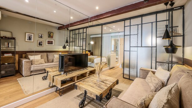 A modern living room with a sofa, coffee table, and TV. - Design loft in CHUECA I3IZQ (Madrid)