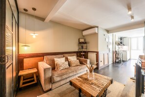 A cozy living room with a sofa, coffee table, and pendant lights. - Design loft in CHUECA I4I (Madrid)