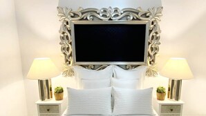 Une chambre à coucher avec un grand lit, deux tables de chevet avec des lampes et une tête de lit décorative.