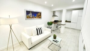Un salon moderne avec un canapé blanc, une table basse et un coin repas comprenant une table et des chaises.