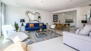 A modern living room with a sofa, a coffee table, and a dining area. - Penthouse with solarium  in Plaza Mayor and Sol (Madrid)