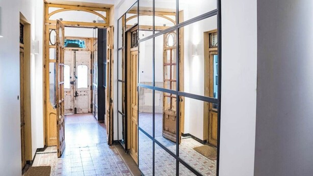 A hallway with wooden doors and a glass partition. - Incredible design apartment 6C (Madrid)