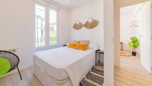 A modern bedroom with a large bed, a window, and a view of the outside.