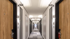 Corredor de hotel com portas numeradas 502, 505 e 507.