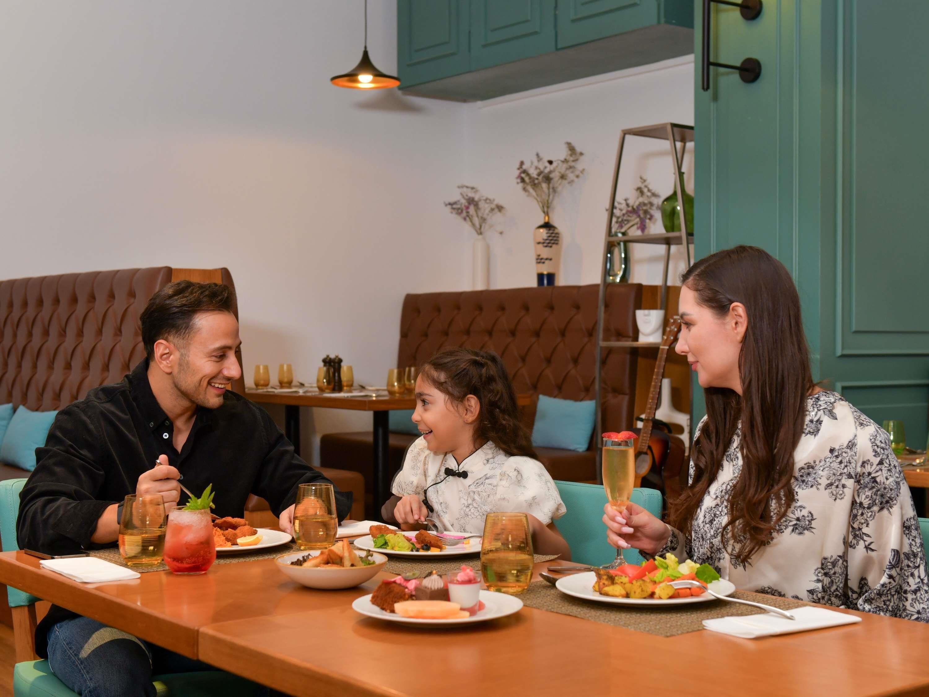 A dining area with a wooden table, cushioned seating, and a decorative vase on the wall.
