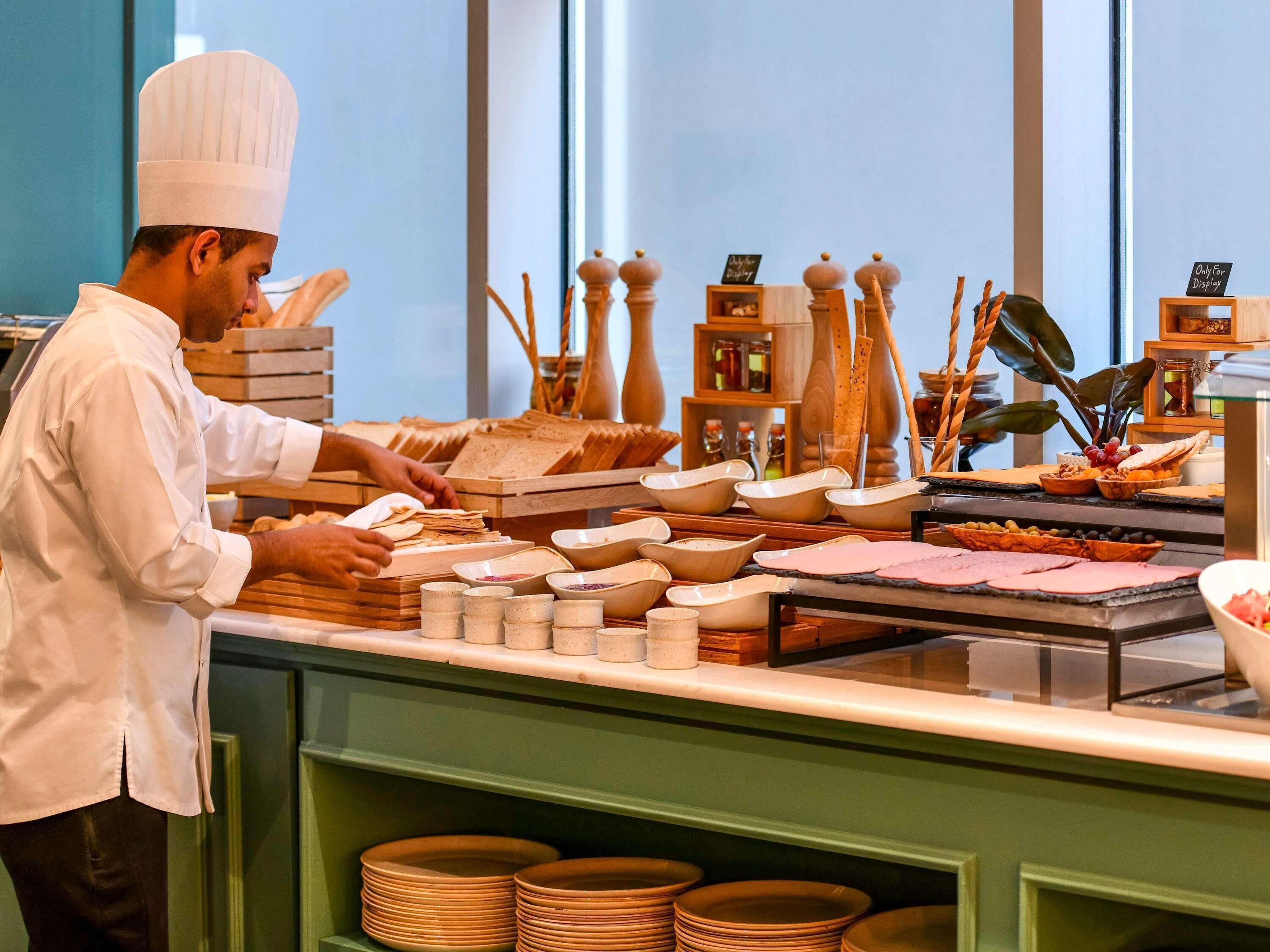 Una mesa de buffet con diversos alimentos y utensilios de servir.
