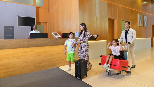 A reception area with a wooden reception desk, a TV screen, and a wall-mounted sign.