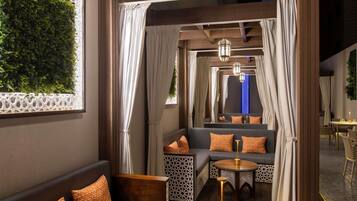 A cozy interior with a sofa, a round table, and a seating area with curtains.