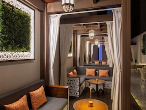 A cozy interior with a sofa, a round table, and a seating area with curtains. - Ibis Doha (Doha)