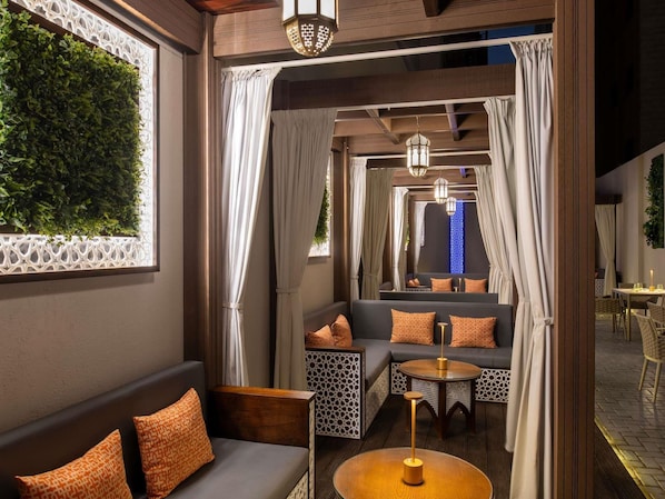 A cozy interior with a sofa, a round table, and a patterned wall.