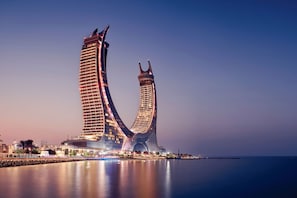 A modern hotel with a unique architectural design featuring two curved towers.