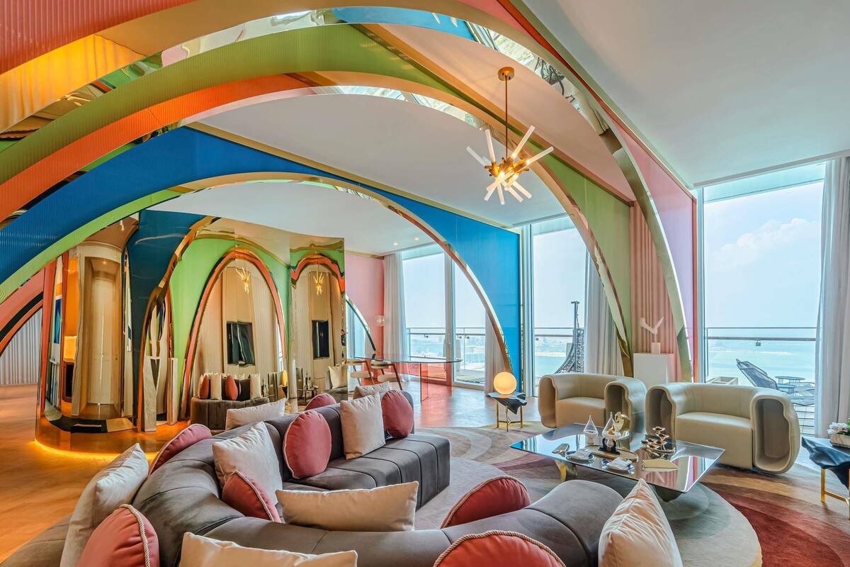A spacious living area with a curved ceiling, a large sofa set, a coffee table, and a view of the sea.