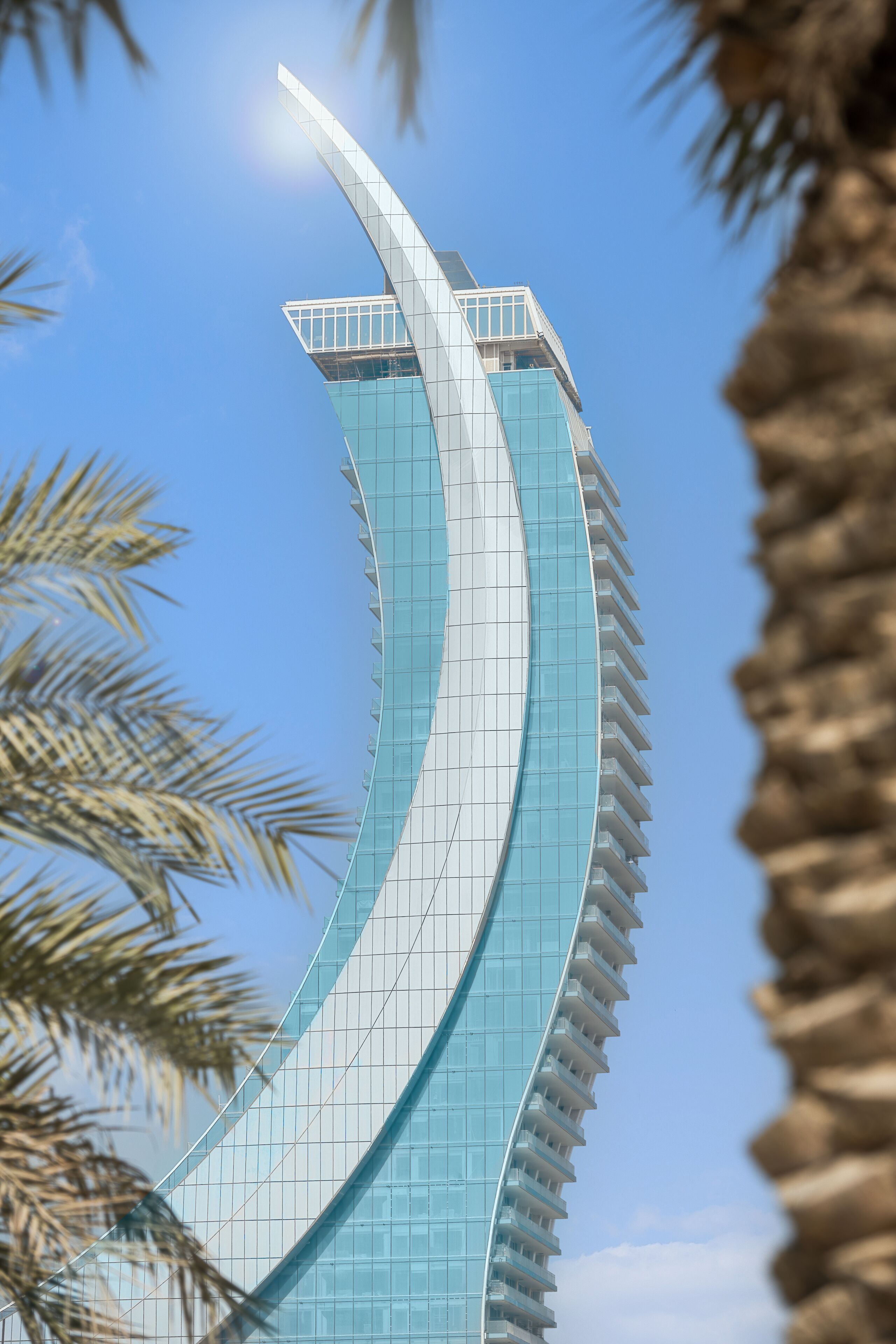 A modern building with a curved glass facade and a flat roof.