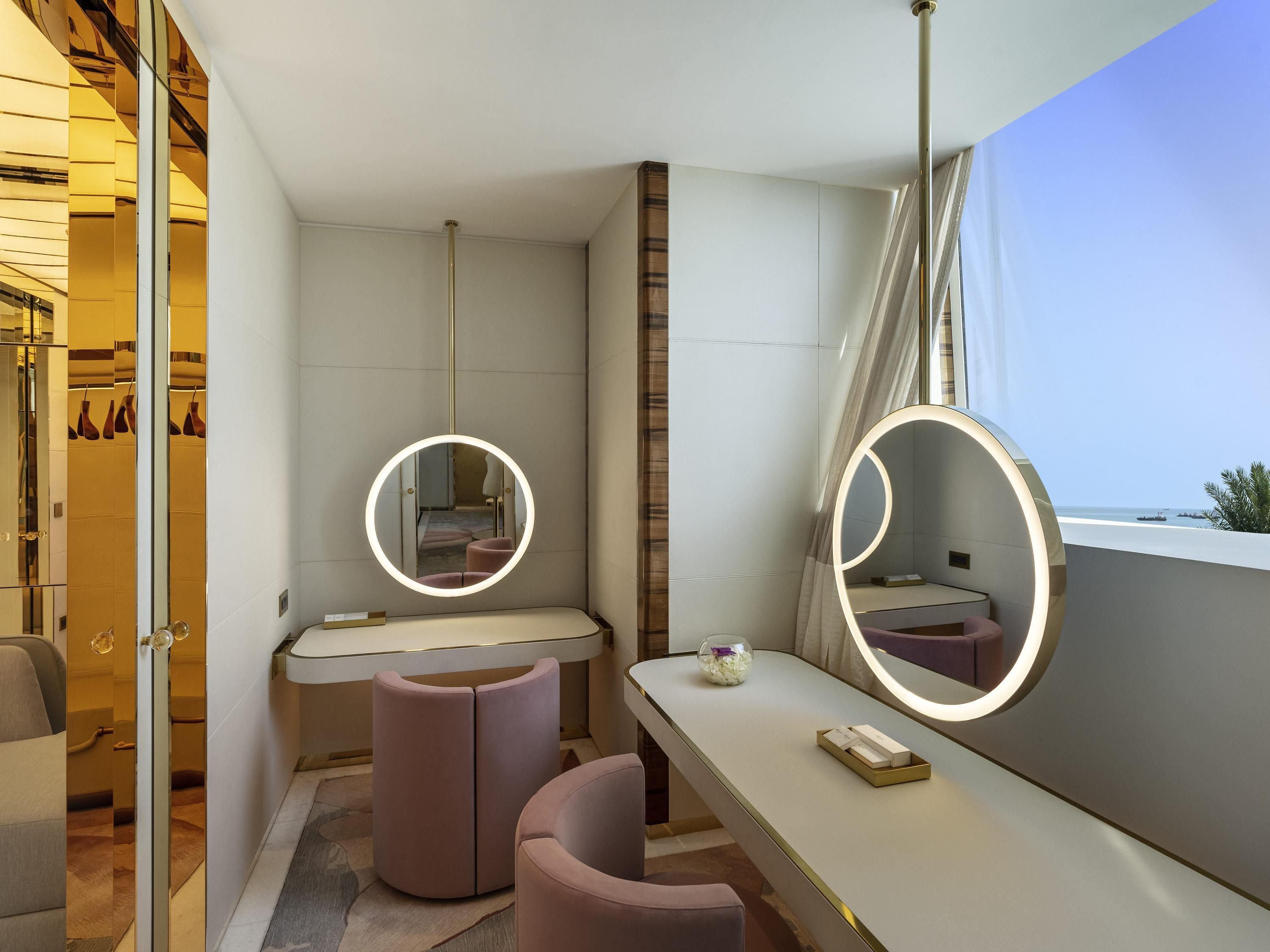 A modern bathroom with a vanity, two mirrors, a toilet, and a shower area.