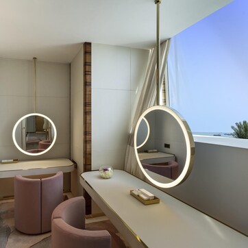 A modern bathroom with a vanity, two mirrors, a toilet, and a shower area.