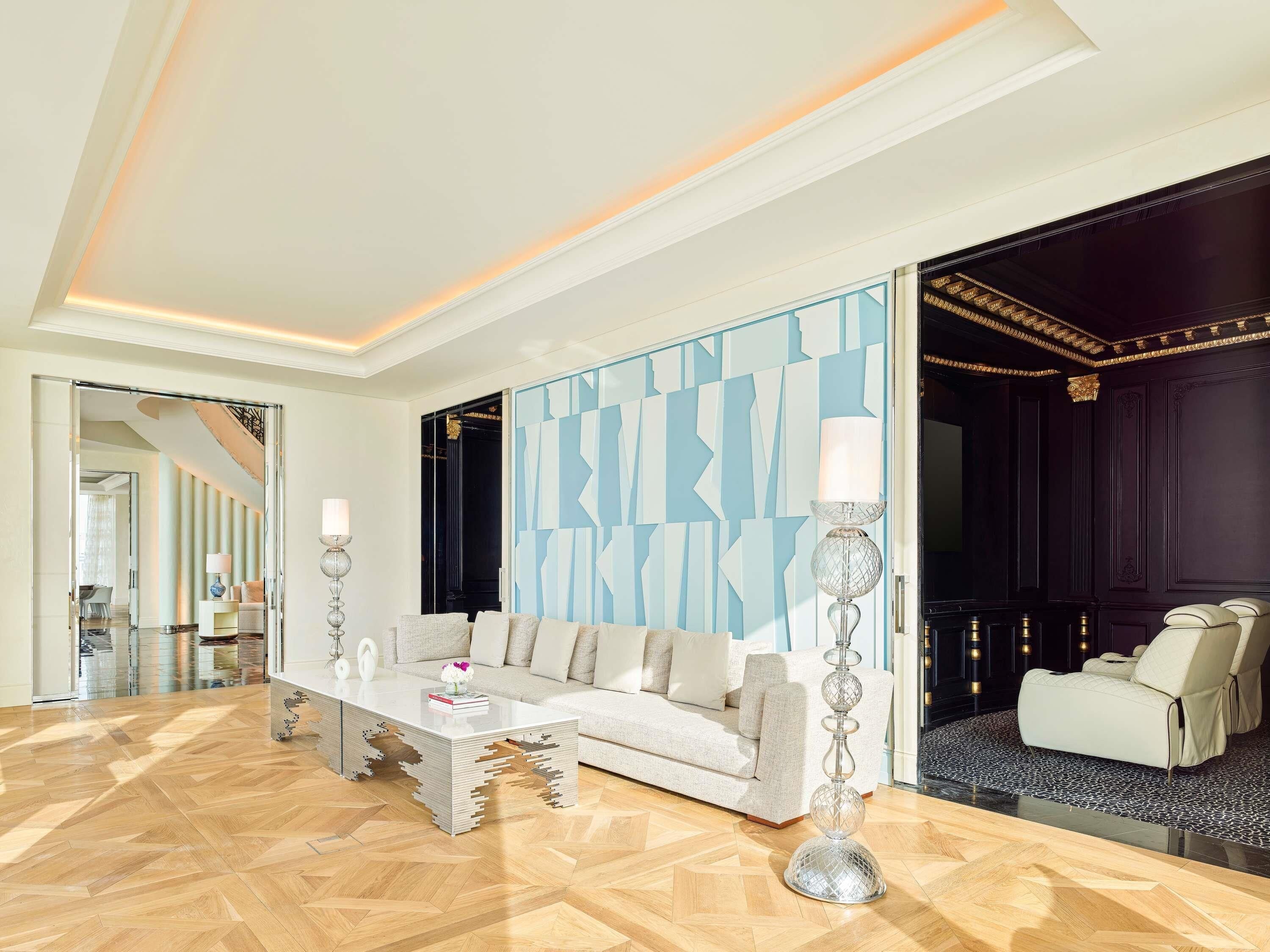 Een moderne woonkamer met een bank, salontafel en decoratieve lampen.