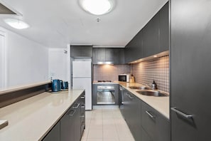 Modern kitchen with a stainless steel sink, oven, and sleek cabinetry.