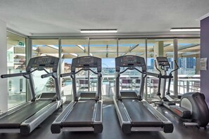A gym with treadmills, exercise bikes, and a rowing machine, with large windows offering a city view. - City Heights! 2Bed/1Bath/1Car/Views ~ CBD (Brisbane City)