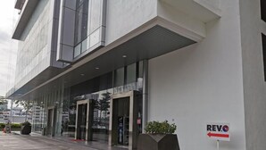 A modern building with a glass entrance and a sign indicating 'REV.0'. - Pavilion Bukit Jalil @ REVO Cozy Studio Suite (Kuala Lumpur)