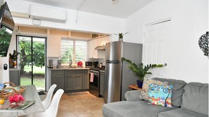 A compact kitchen with a refrigerator, stove, and dining area.