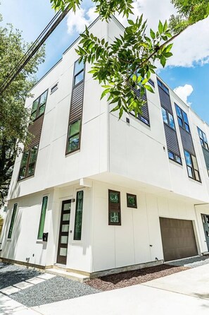 Ein modernes, zweistöckiges Gebäude mit Flachdach, großen Fenstern und einer Garage.
