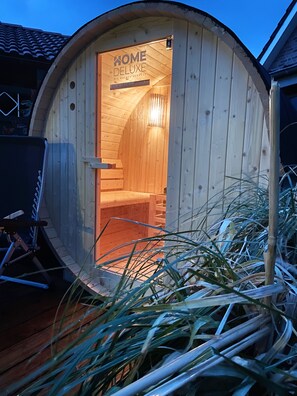 A wooden structure with a sign that reads "HOME DELUXE" and a visible interior with a staircase.