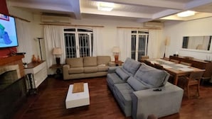 Ein Wohnzimmer mit einer Couch, einem Couchtisch, einem Fernseher und einem Kamin.