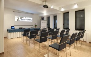 Ein Konferenzraum mit einem langen Tisch, Stühlen, einer Projektionsleinwand und einem Willkommensschild.