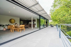 Una cocina moderna con comedor, ventanas amplias y un balcón con vistas a zonas verdes.