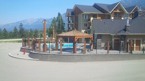 A resort with a pool, a gazebo, and a mountain view.
