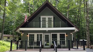 A lodge with a two-story structure, a covered deck, and a flag.