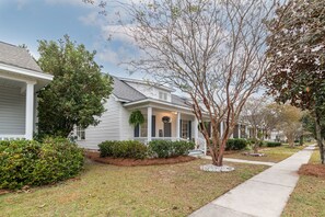 A residential street with houses featuring front porches and well-maintained lawns. - Encanto of the Lowcountry in Old Town Bluffton (Bluffton)