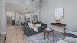 A spacious living area with a gray sofa, a coffee table, and a blue patterned rug.