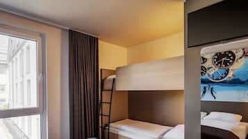 Una habitación de hotel con una litera, una ventana con cortinas, un reloj de pared y un cuadro.