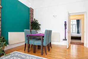 Un coin repas avec des murs de couleur turquoise, un radiateur blanc et un plancher en bois.