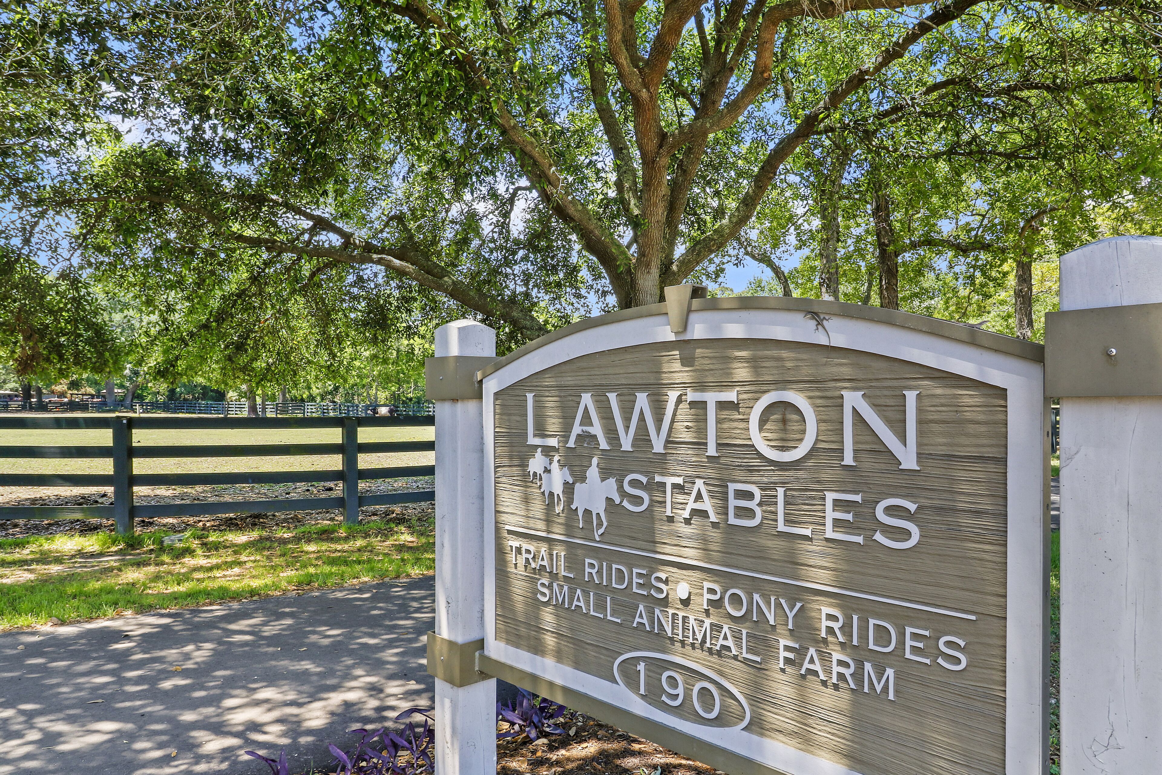 A sign for Lawton Stables offering trail rides, pony rides, and a small animal farm.