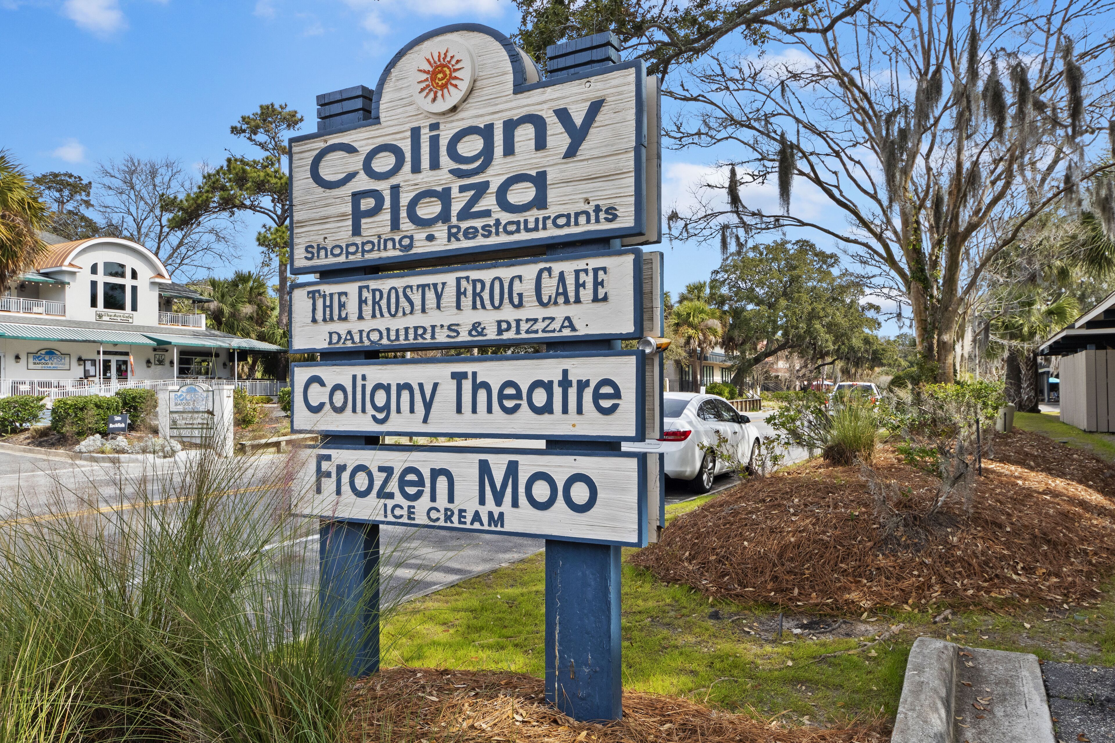 Señal de Coligny Plaza con anuncios para el Café Frosty Frog, el Teatro Coligny y la heladería Frozen Moo.