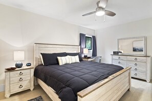 A bedroom with a bed, nightstand, dresser, and ceiling fan. - Xanadu 2 bedroom condo w/ Pool, Tennis walk to Beach, Coligny Celebration Park! (Hilton Head Island)
