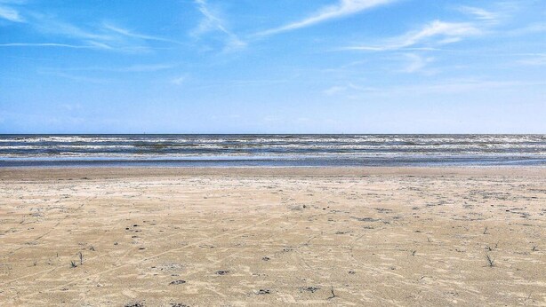 Een strand met heldere lucht en oceaan golven.
