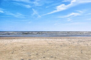 A beach with a clear sky and ocean waves.